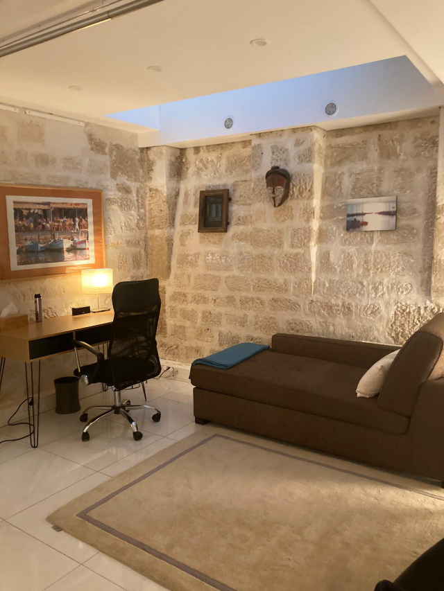 Banquette de thérapie haute, sans bords, plaid doux et oreiller, décor minimal apaisant, sans personne.